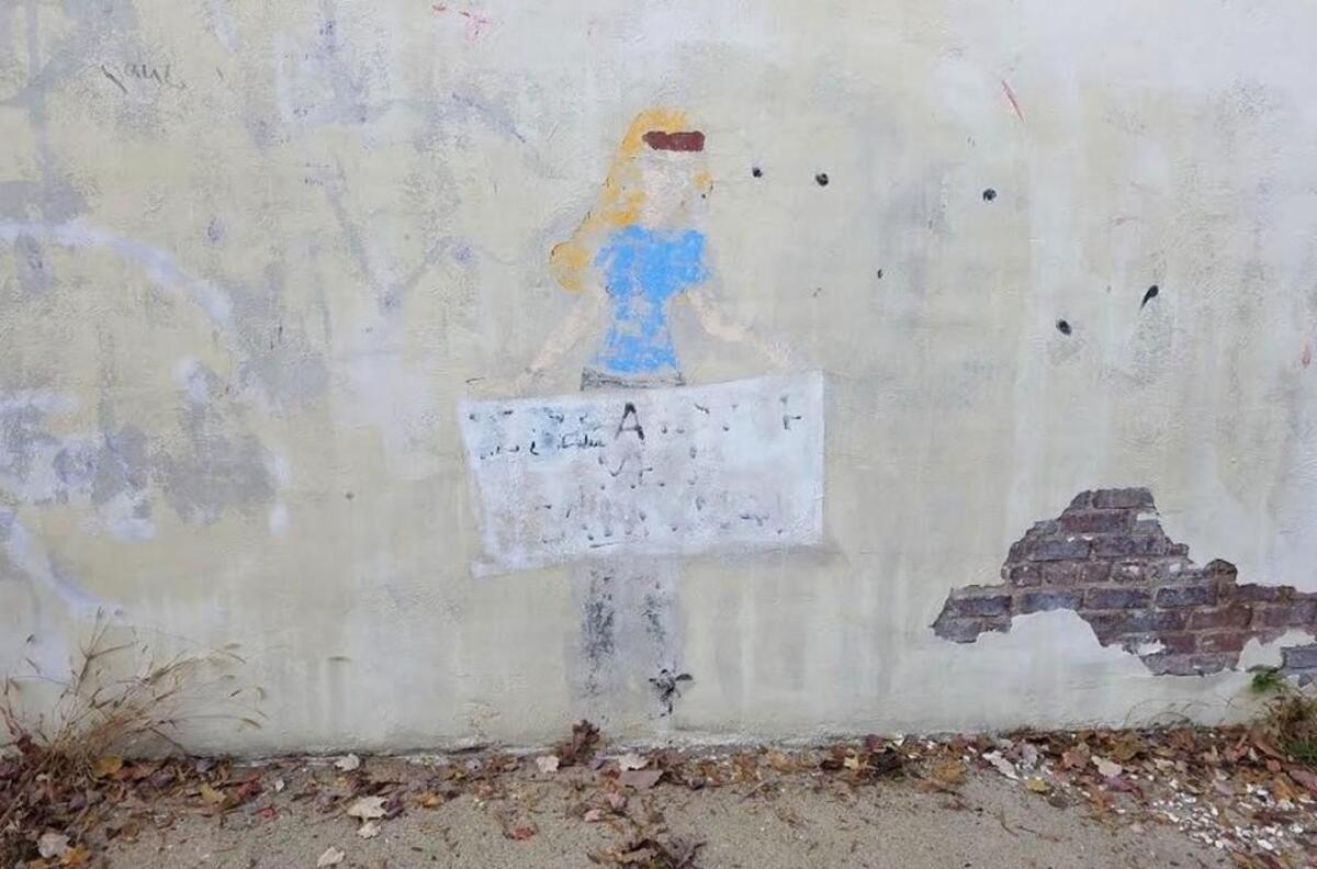 Sleeping Beauty heroine Aurora, part of the ‘No Damsel’ exhibit at CAM Raleigh, photographed Nov. 20, 2017. It has been partly erased in an apparently act of vandalism. The painting is one of three outside the museum painted by Dorian Lynde. This mural was one of the more politically charged, with Aurora carrying a sign that said, “Mind Your Own Uterus.”