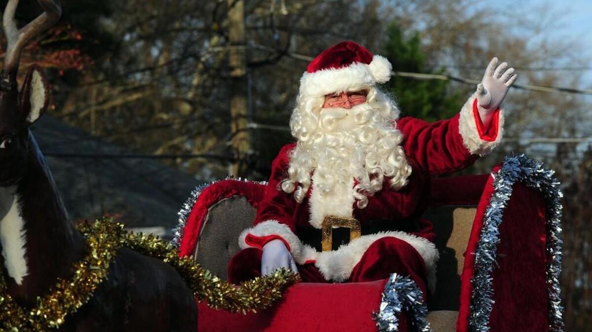 Santa waves to the crowds from his sleigh in the 2015 Cary Jaycees Christmas Parade.