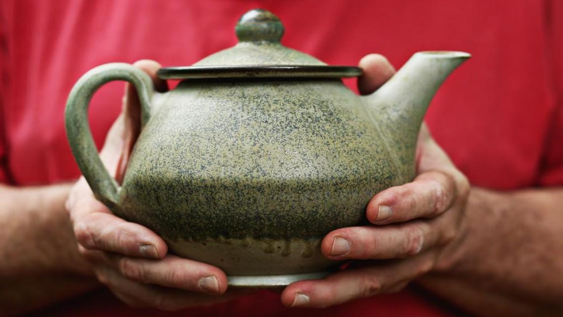 North Carolina potter Brad Tucker holds one of his pieces, “Untitled,” from Cedar Creek Gallery’s National Teapot Show in Creedmoor.