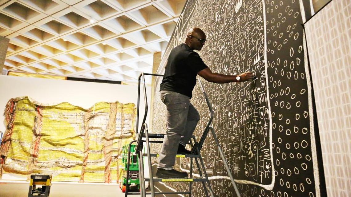 Nigerian artist Victor Ekpuk puts the finishing touches on a chalk drawing, “Divinity,” June 7, 2017, created for the African art gallery’s opening in a new space at N.C. Museum of Art in Raleigh.