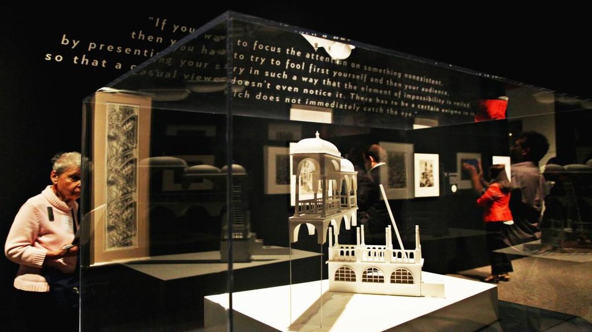 Viewers examine the works of M.C. Escher Wednesday, October 14, 2015, during the media preview of North Carolina Museum of Art's exhibit "The Worlds of M.C. Escher: Nature, Science, and Imagination."