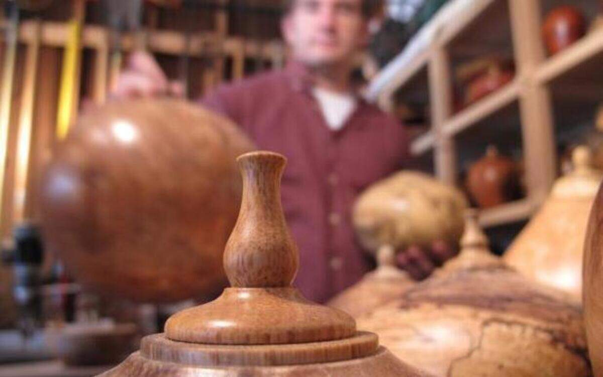 
Woodturner Jason Van Duyn arranges funerary urns in his Raleigh studio. His urns range in price from $300 for a 70-cubic-inch piece made from a black cherry stump to $5,200 for a 450-cubic-inch red maple burl “companion” urn. Van Duyn makes urns that he hopes his clients will be proud to display in their homes. 
