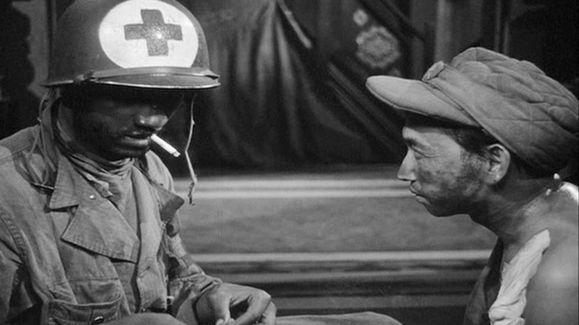 Cpl. Thomson (actor James Edwards) and the communist Prisoner (played by Harold Fong) talk about American politics and racial inequity in Sam Fuller’s pioneering Korean War film “The Steel Helmet” (1951).