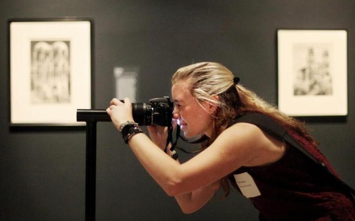 N.C. State University student Victoria Crocker, right, tries to take a photo through a viewfinder of a 3-D model based on Escher's "Belvedere" Wednesday, October 14, 2015, during the media preview of North Carolina Museum of Art's exhibit "The Worlds of M.C. Escher: Nature, Science, and Imagination."