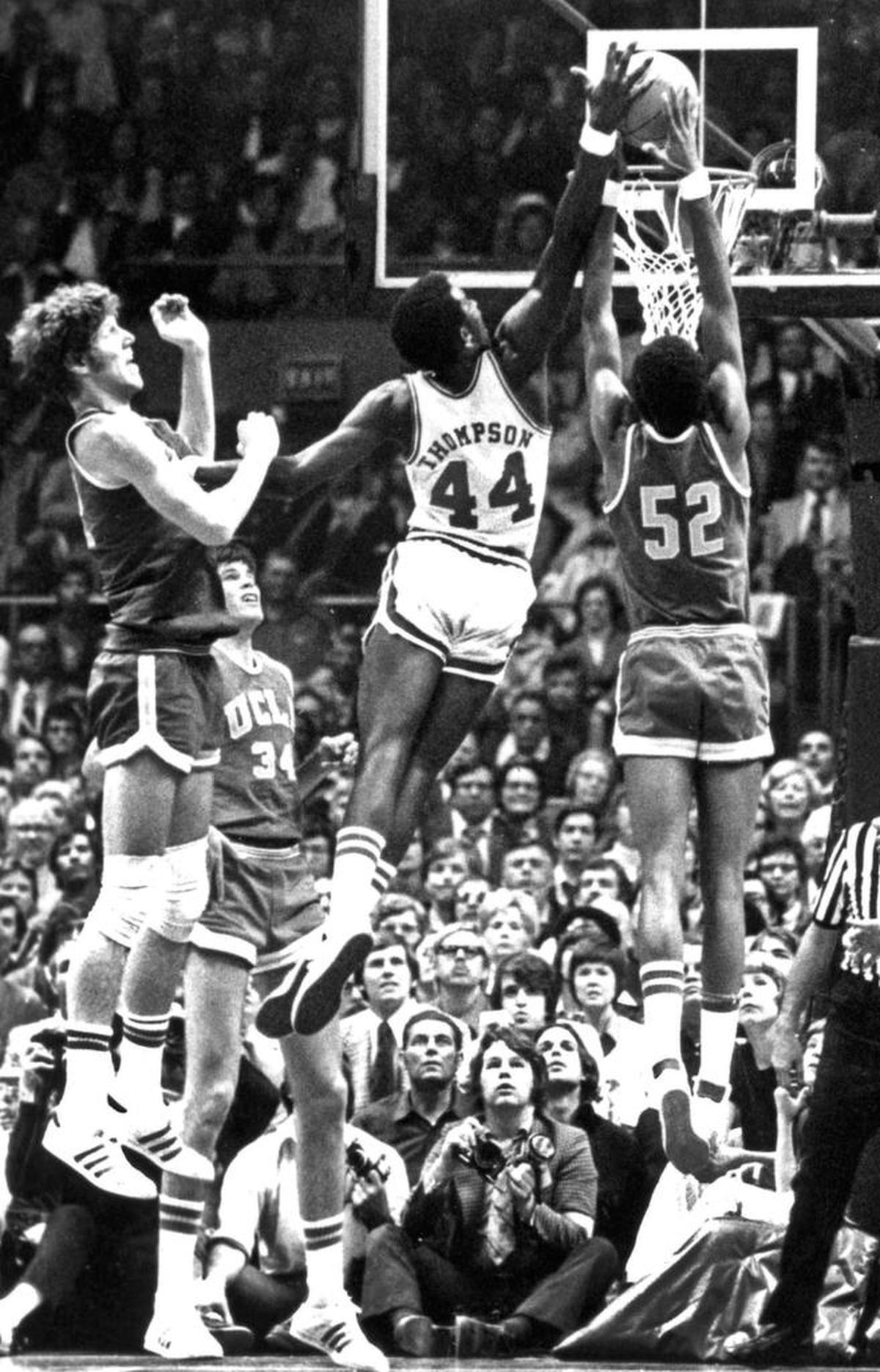 David Thompson soars above the rim to block a shot by UCLA’s Keith Wilkes during an NCAA semifinal game in 1974. N.C. State won that game and went on to win the 1974 national title.