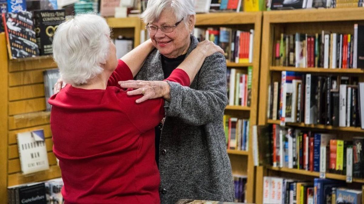 Raleigh writer’s champion and Quail Ridge Books founder Nancy Olson hugs seasonal gift wrapper, Brenda Holloman, left, in December 2015 at the bookstore in Raleigh. Olson died Sunday.