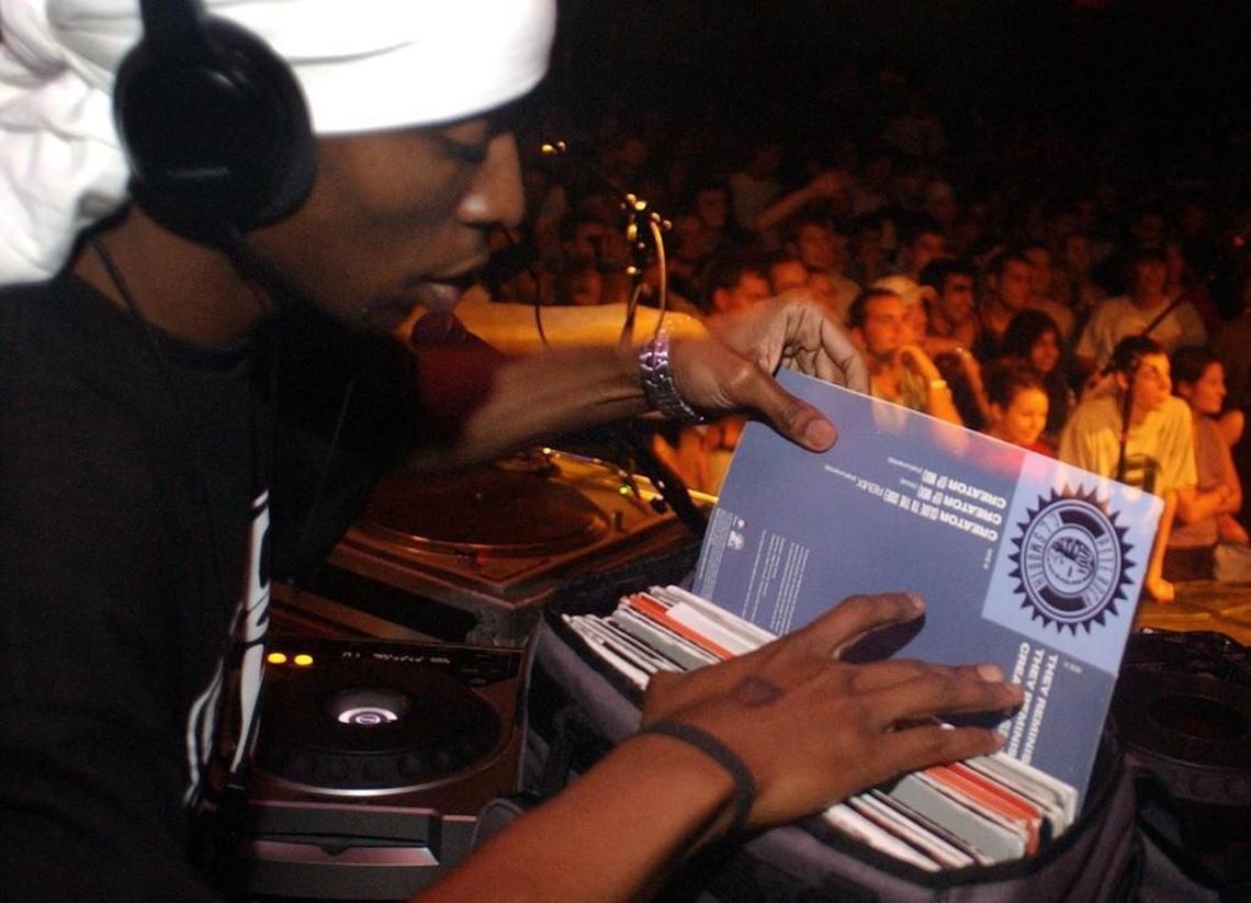 9th Wonder, photographed in 2002, reaches into the crates for an album to mix during a concert at the Cat’s Cradle.