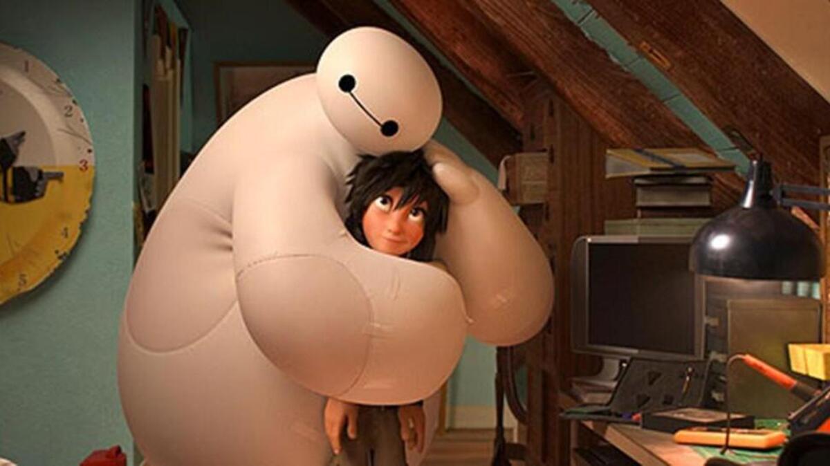 Young scientist Hiro Hamada (voiced by Ryan Potter) and health care robot Baymax (Scott Adsit) hug in a scene from Disney’s film, “Big Hero 6.”