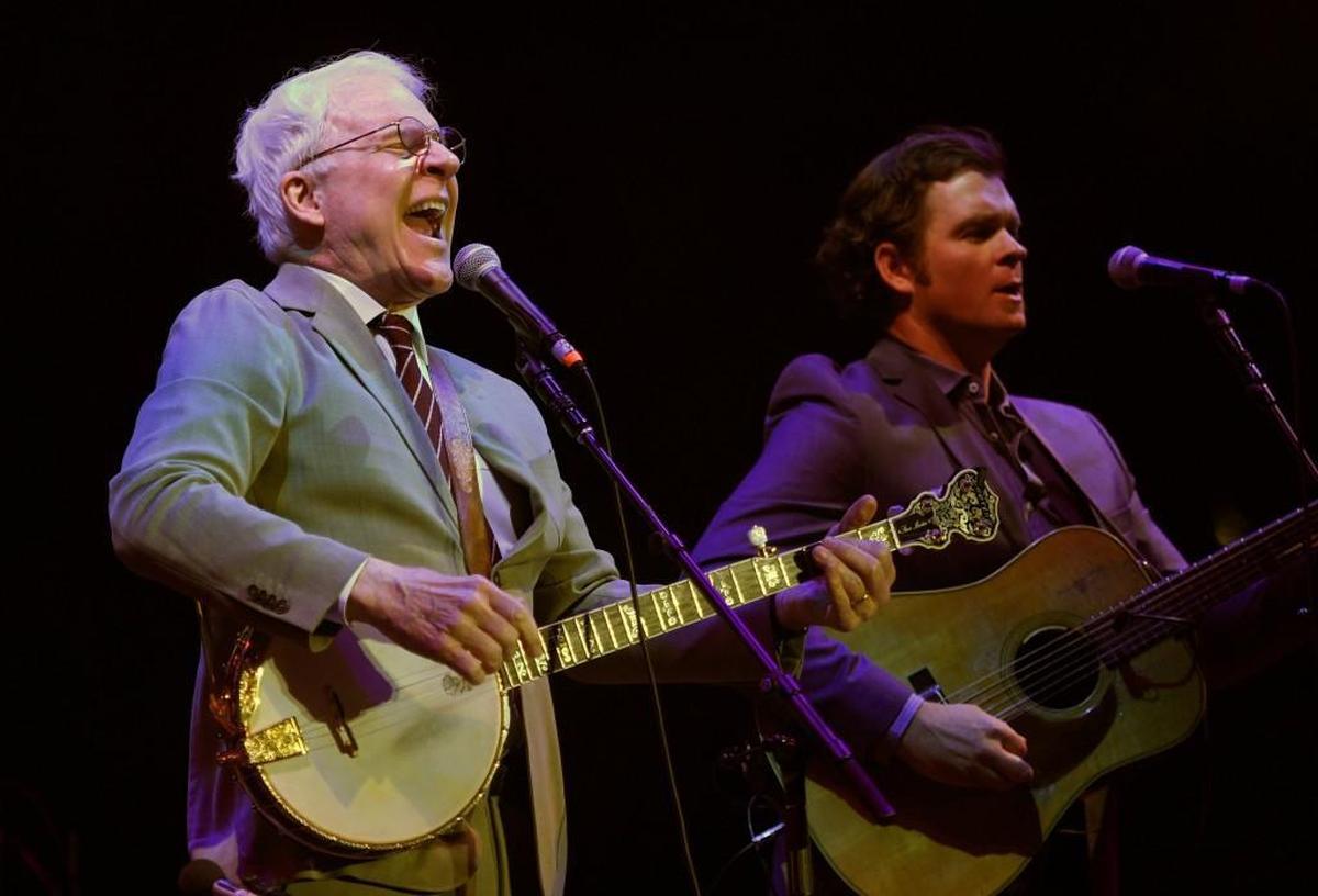 Steve Martin performs with Steep Canyon Rangers during Wide Open Bluegrass in 2017 at Raleigh’s Red Hat Amphitheater. The group’s twisted breakup song “Caroline” has a line about the protagonist seeking someone “who swears a blue streak when the Tar Heels lose the quarter-finals.”