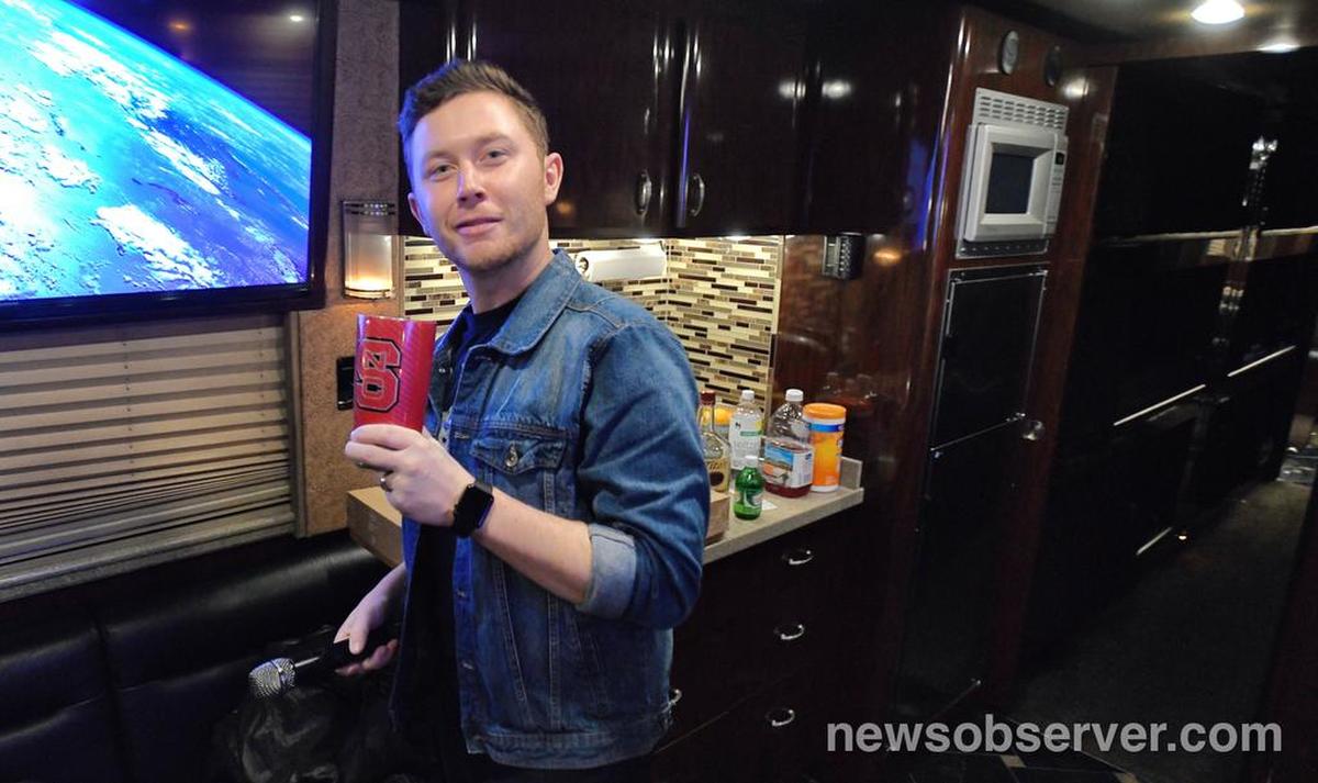 Scotty McCreery flashes his NC State Wolfpack cup as he leaves his tour bus to take the stage for his homecoming show at The Ritz in Raleigh, N.C. Saturday night, Jan. 19, 2019.