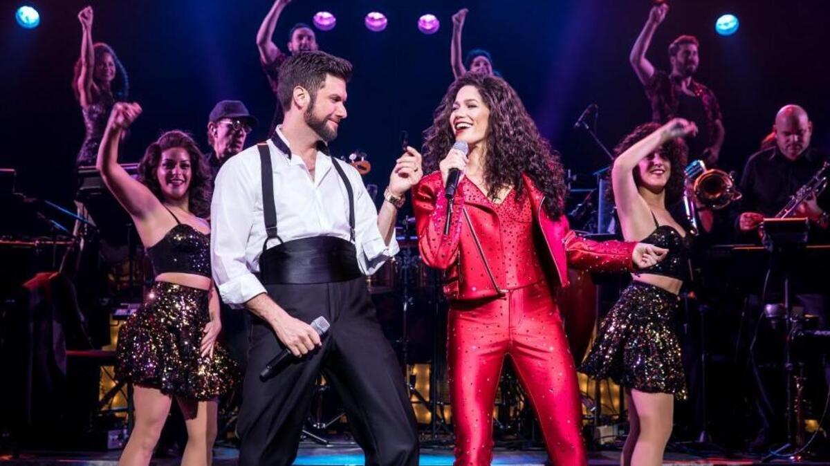 From left, Mauricio Martinez (as Emilio Estefan) and Christie Prades (as Gloria Estefan) and Company, right, in “On Your Feet!” The musical about the lives of Gloria and Emilio Estefan comes to the Durham Performing Arts Center Jan. 2-7.