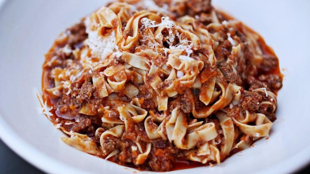 Bolognese, made with ground beef and pork, is rich and meaty in a rosemary-tinged tomato sauce, twirled into a tangle of supple tagliatelle.