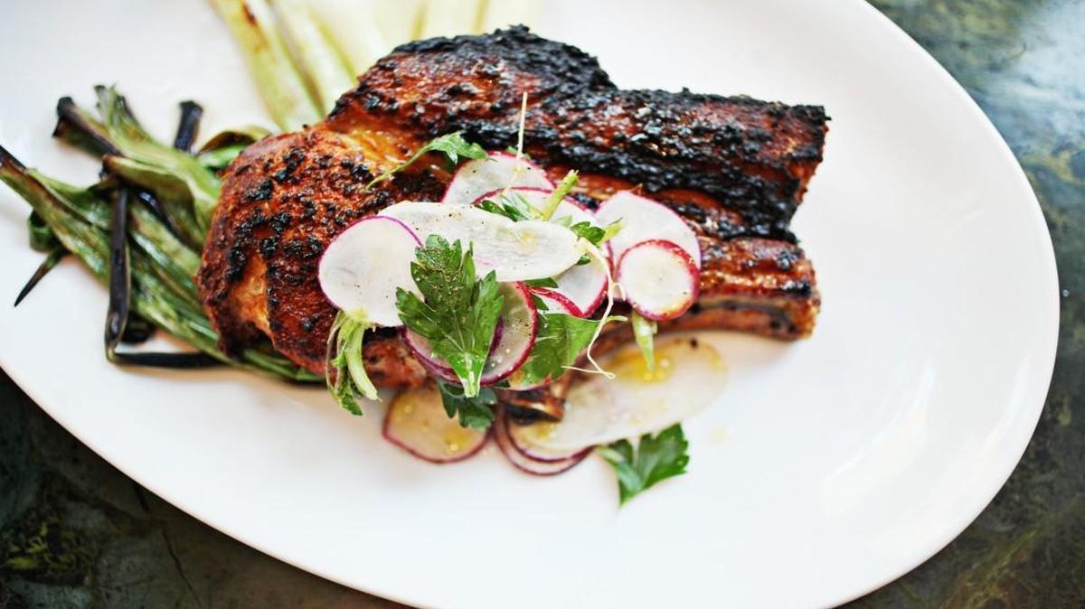 Roasted country rib chop with charred spring onion and Elysian Fields Farm radishes at The Durham.