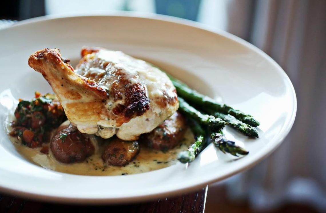 The Roasted Chicken is napped with a dill beurre blanc sauce and served with grilled asparagus, buttery rissole potatoes and a vibrant tomato relish that rounds out the presentation at Flair Restaurant & Wine Bar in Chapel Hill.