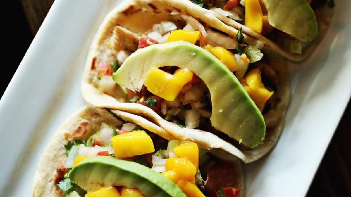 Tacos come three to an order, generously filled and neatly arranged on a long rectangular platter at La Santa in Raleigh. The menu lists eight variations on the theme including pescado, a culinary kaleidoscope of grilled mahi, cucumber, tomato, mango and avocado, drizzled with a creamy cilantro sauce and served on flour tortillas.