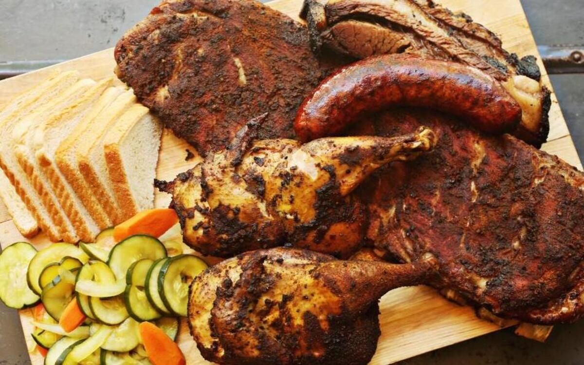 All meats are cooked in a gas-fired smoker over pecan wood and served with pickles and white bread at Bare Bones in downtown Raleigh.