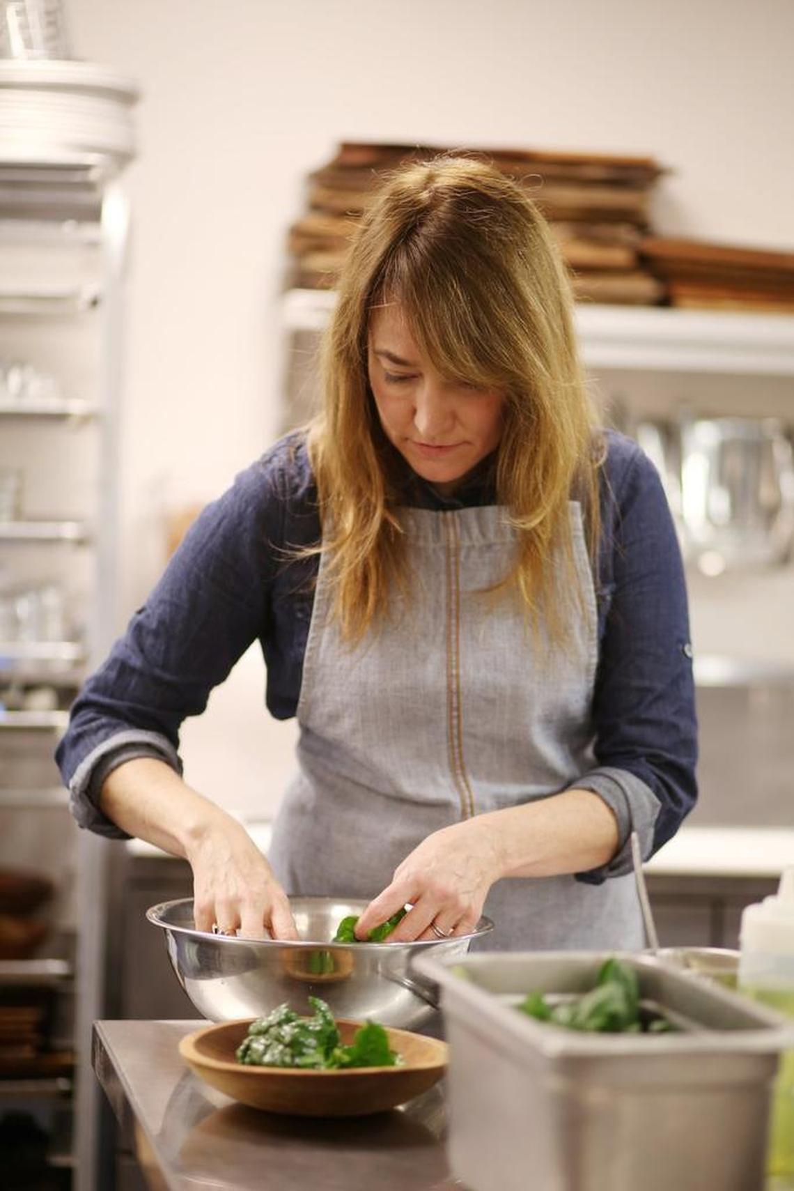 Chef Andrea Reusing of The Durham Restaurant prepares the Warm Savoy Spinach Salad in her restaurant kitchen. Reusing recently had a hand in designing three salads for fast casual chain CHOPT, including one featuring fall ingredients from North Carolina.