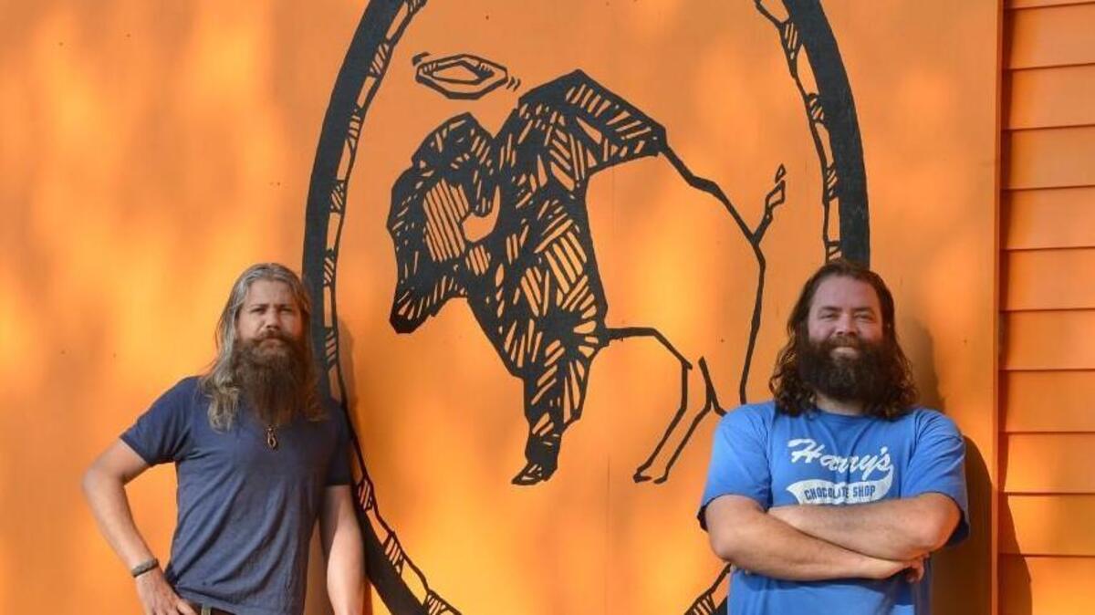 Mark Dundas, left, and business partner, Dain Phelan in front of their brightly colored chicken wing restaurant Heavenly Buffaloes in 2014. A Chapel Hill location of Heavenly Buffaloes will open on Franklin Street in March.