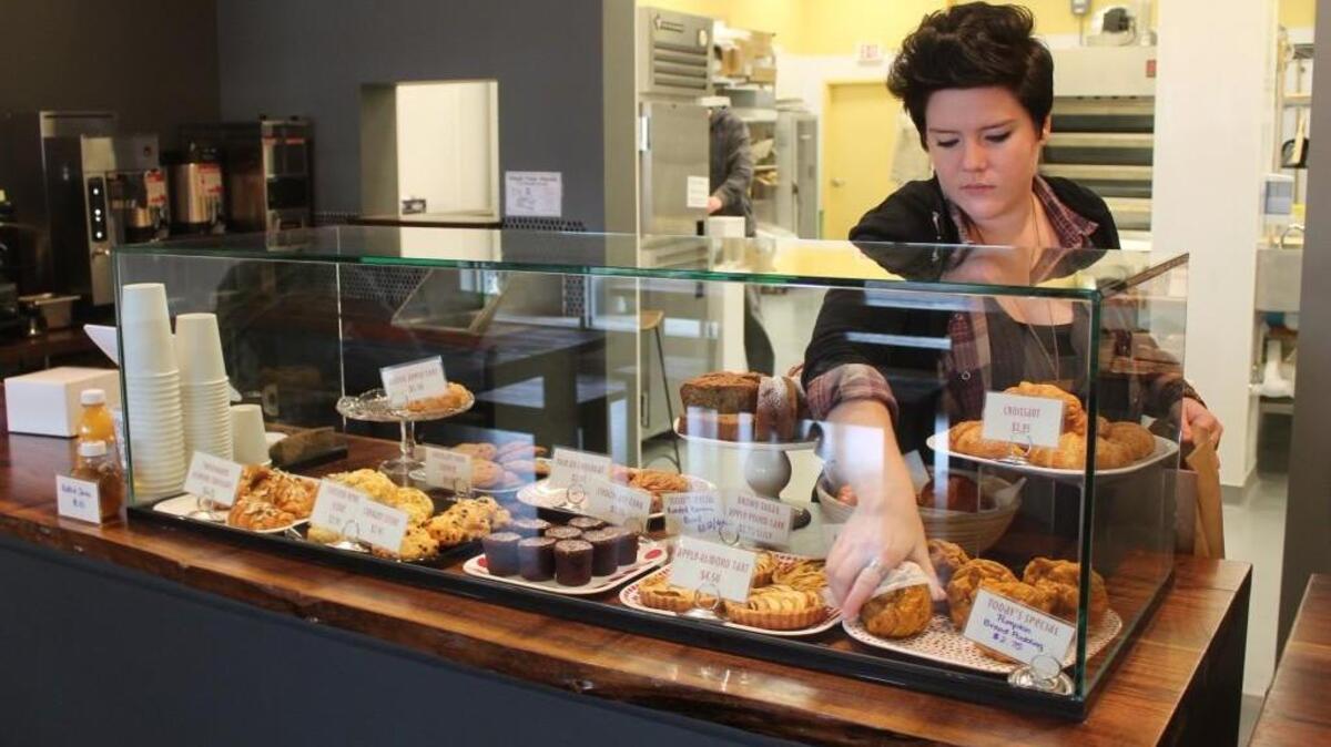 Barista Sam Robinson gets pumpkin bread pudding from the showcase at Night Kitchen Bakehouse & Cafe.