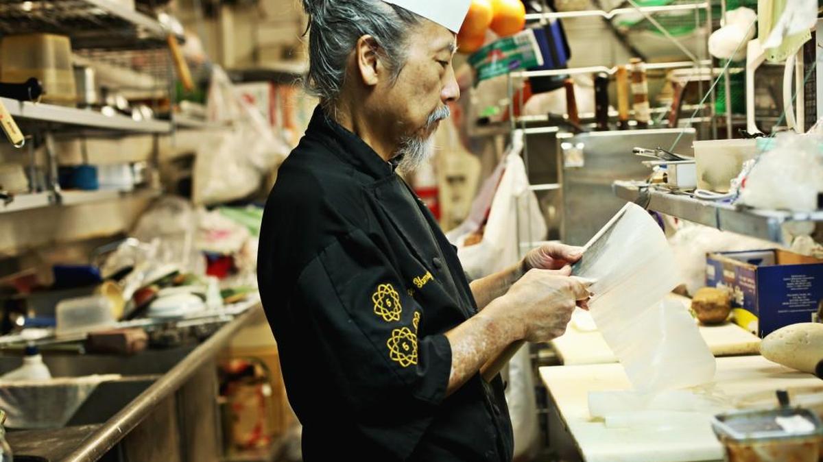 George Yamazawa demonstrates a highly-skilled technique called katsuramuki to cut daikon radish into paper-thin sheets to create a long scroll in his Durham restaurant, Yamazushi, on Friday, Oct. 23, 2015.
