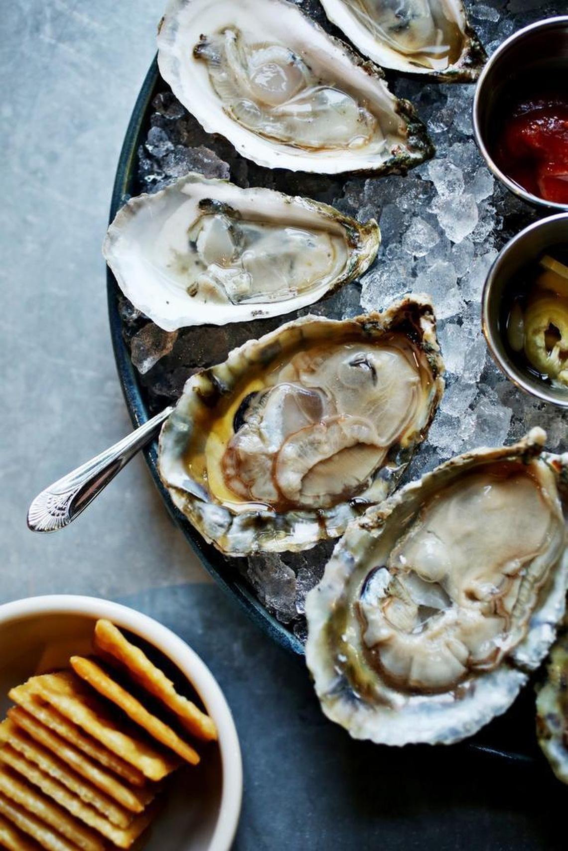 Raw 1/2 dozen oysters are served with cocktail sauce, pickled banana peppers, lemon, fried saltines and mignonette at St. Roch Fine Oysters + Bar in downtown Raleigh. Critic Greg Cox quite likes oysters.