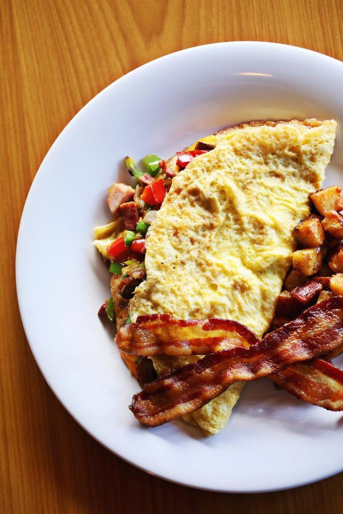 The All American Omelet is served with potatoes and a side of bacon at Just Cookin' in Garner.