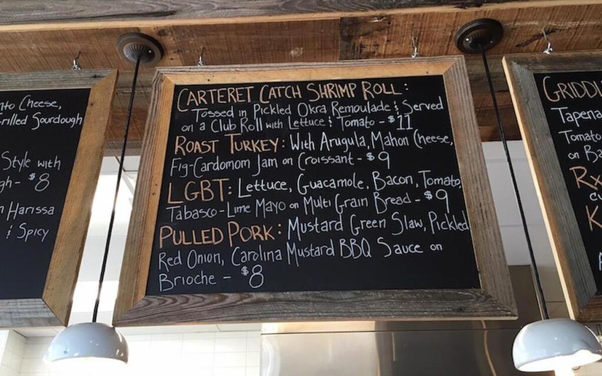 Person Street Pharmacy’s Carteret Catch Shrimp Roll is a Carolina twist on a Maine lobster roll, featuring shrimp tossed in a pickled okra remoulade, served on a club roll with lettuce and tomato.