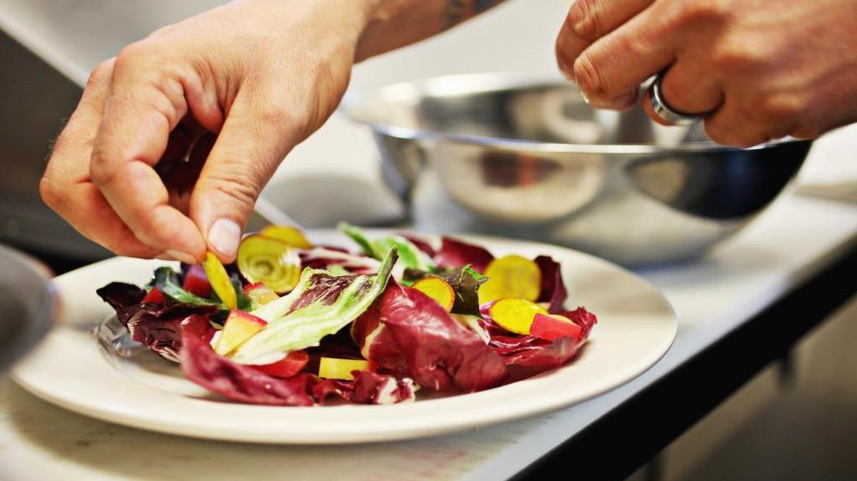 Chef Scott Crawford of Standard Foods in Raleigh arranges a salad just before lunch at the restaurant in December. In addition to the restaurant, there is a butcher and grocery with selected local and regional products from small farmers and producers.