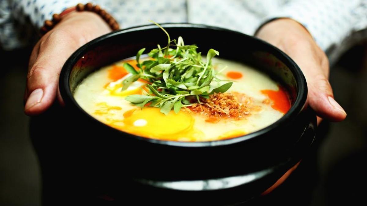 Brewery Bhavana co-founder Vansana Nolintha holds one of his favorite dishes, the Rice Congee made up of rice soup with chicken, ginger, herbs and egg at Brewery Bhavana.