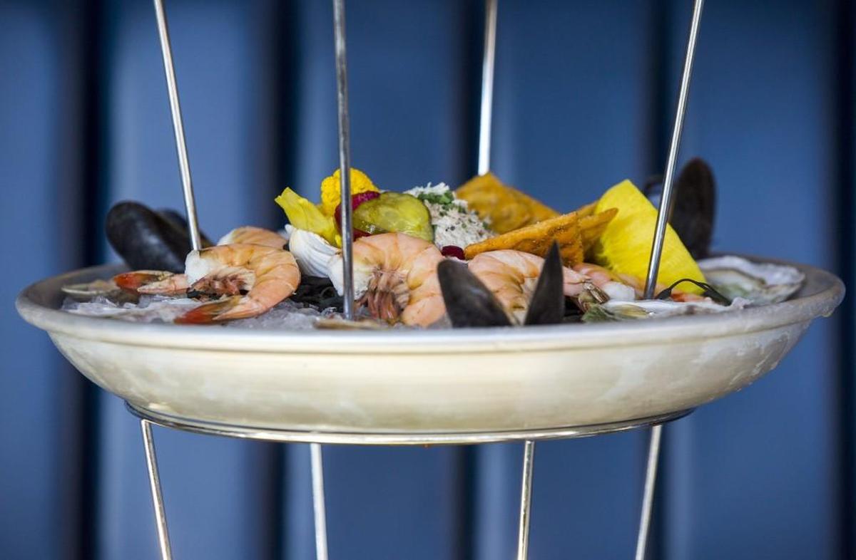 The USS Nimitz towers above the table with its three tiers of lobster, oysters, shrimp, clams, mussels, crab claws, king crab, ceviche, tartare and smoked fish dip at Saint James Seafood on Thursday, Mar. 14, 2018, in Durham, NC.
