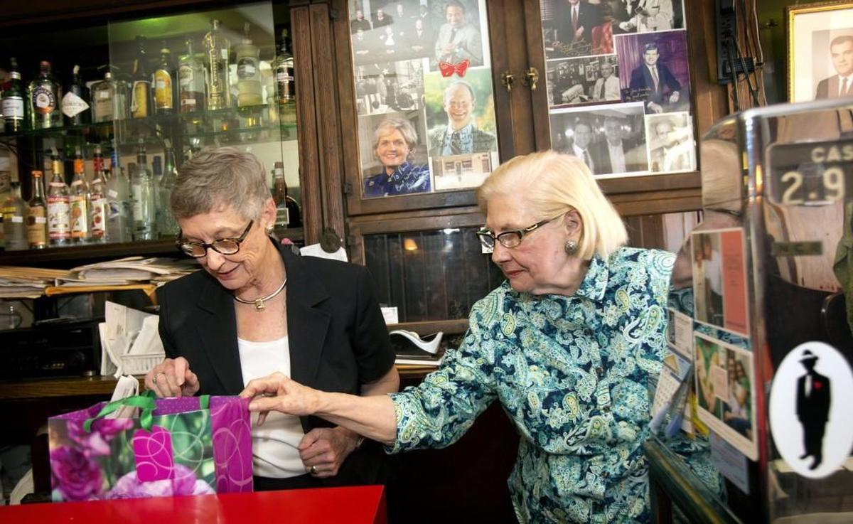 After treating N.C. State Chief Supreme Court Justice Sarah Parker, left, and her colleagues to lunch, Floye Dombalis, right, owner of The Mecca Restaurant, gives Parker a present on Aug. 19, 2014.