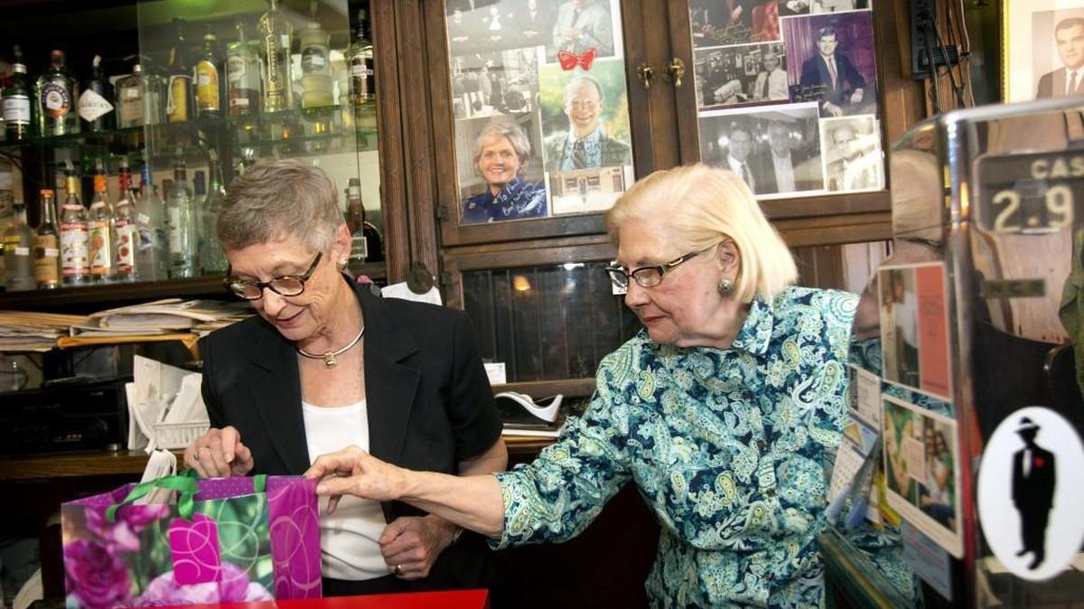 After treating N.C. State Chief Supreme Court Justice Sarah Parker, left, and her colleagues to lunch, Floye Dombalis, right, owner of The Mecca Restaurant, gives Parker a present on Aug. 19, 2014.