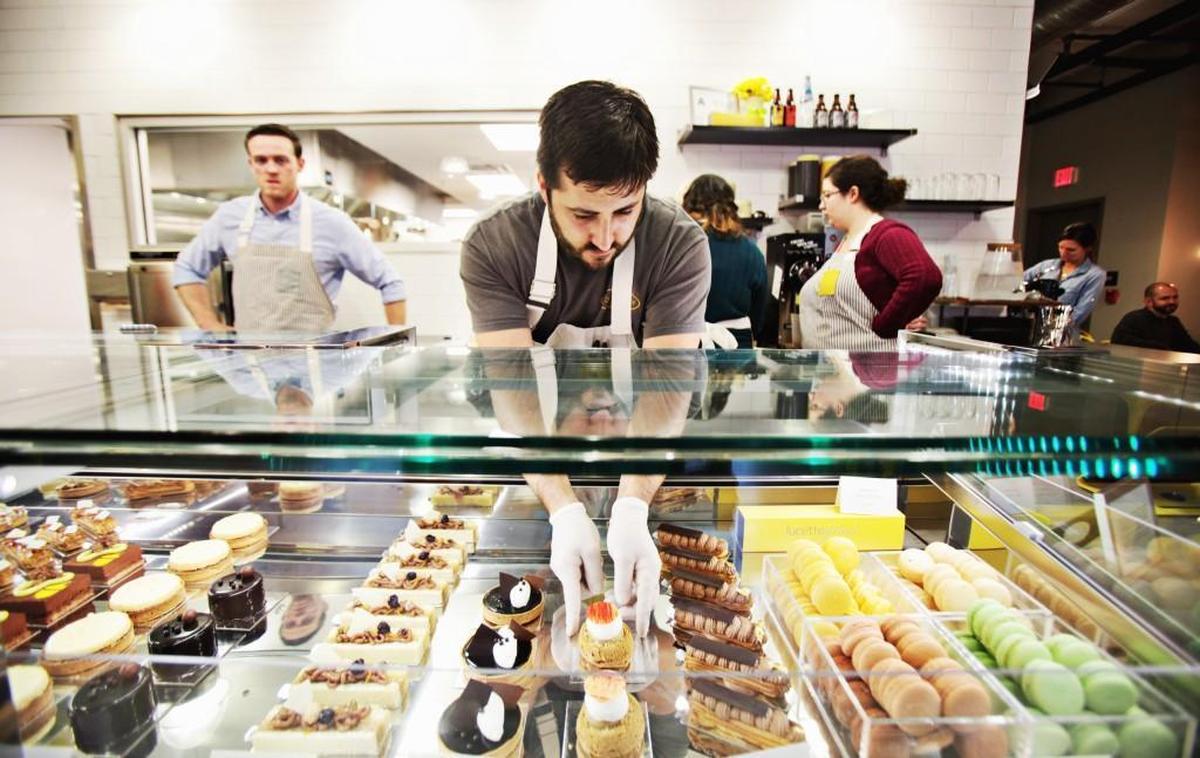Daniel Benjamin, center, arranges baked goods in lucettegrace. Benjamin, formerly of the tony The Umstead Hotel & Spa in Cary, opened lucettegrace, a modern patisserie in downtown Raleigh.