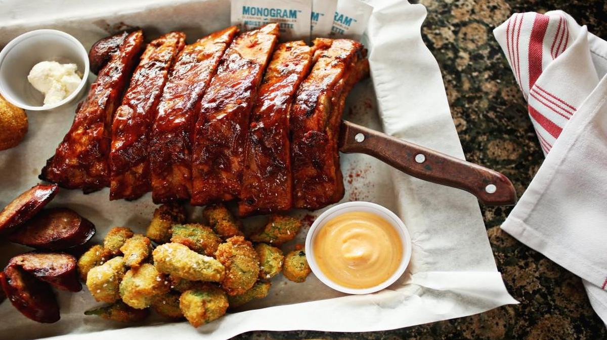 The hickory smoked pasture-raised baby back ribs are cooked falling off the bone with CrossTies' signature sauce. Here, they are served with hush puppies with honey butter, fried okra and spicy smoked Italian rope sausage.