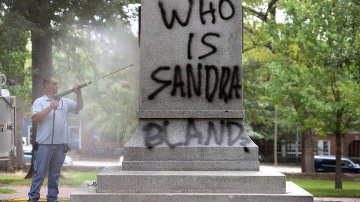 
UNC Facilities worker Chris Moore uses a pressure washer to try and remove spray paint from the Confederate War Memorial on the campus of UNC-Chapel Hill Tuesday, August 18, 2015. The memorial was vandalized in early July by protesters after the Charleston massacre. 
