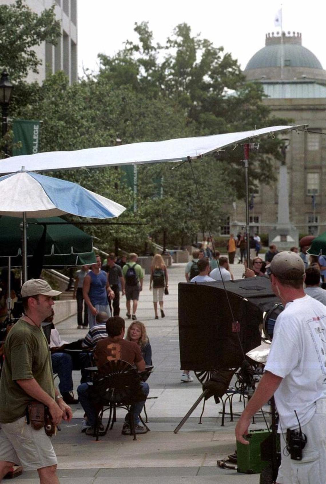 Filming of the WB television series “Dawson’s Creek” takes place July 25, 2001, in downtown Raleigh, N.C. “Dawson’s Creek” producers filmed the show in Wilmington, N.C., for several seasons but filmed some scenes in the Triangle. Michelle Williams and Kerr Smith, two of the show’s stars, sit at a table in the lower left.