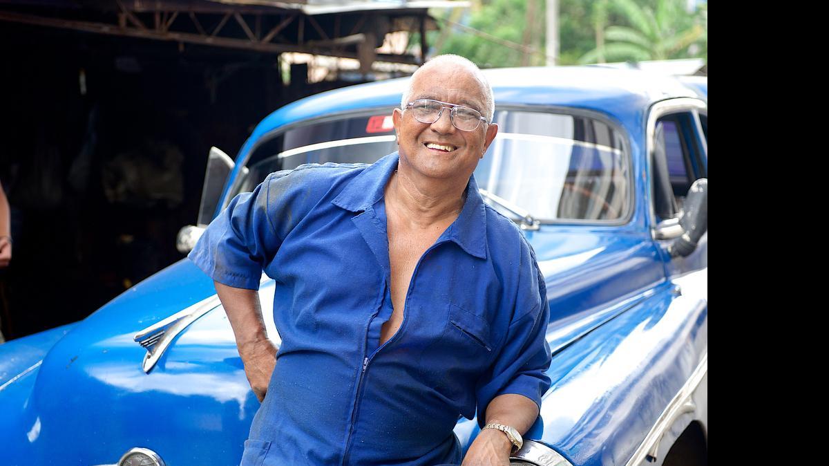 
Demetrio Montalvo standing in front of a car on “Cuban Chrome.”

