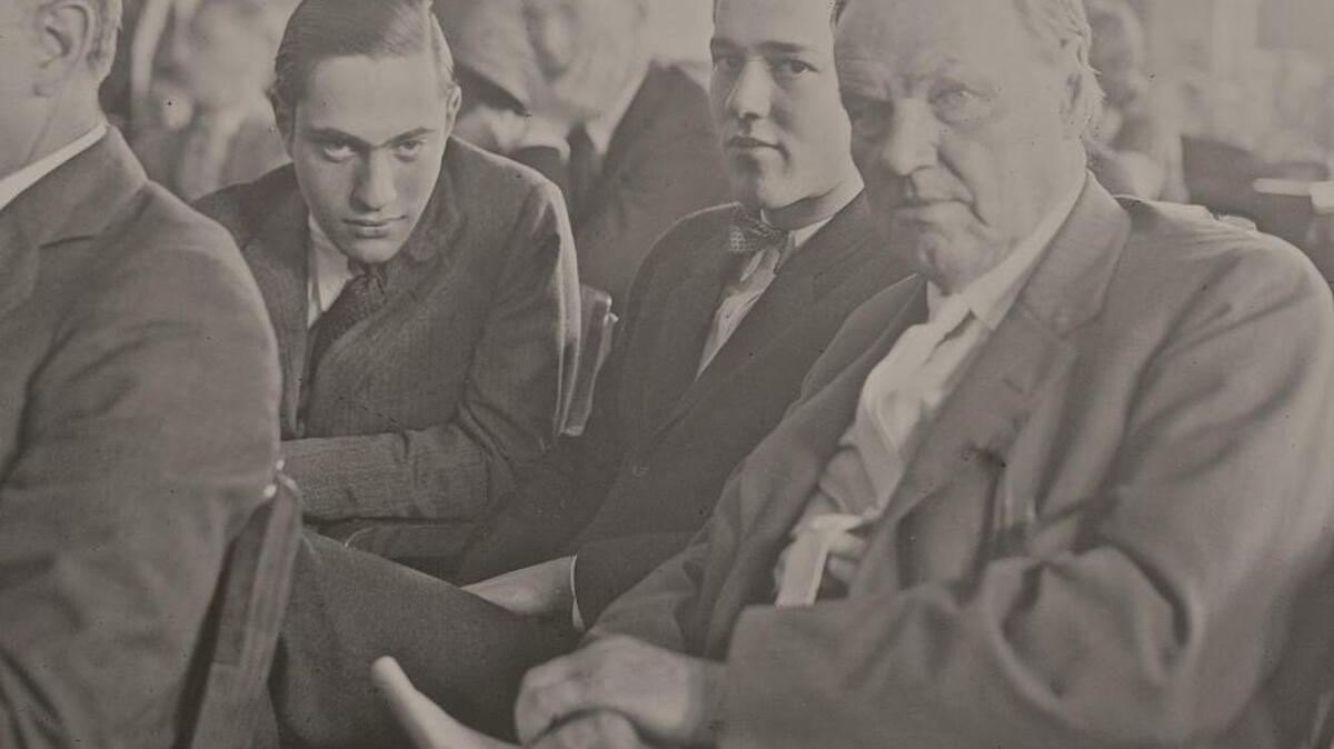 Richard Loeb (left), Nathan Leopold, Jr. (center) and defense attorney Clarence Darrow in a crowded courtroom in Chicago, Illinois, during the Leopold and Loeb murder trial, July 24, 1924. Benjamin Bachrach, defense attorney, is seated in front of Darrow.