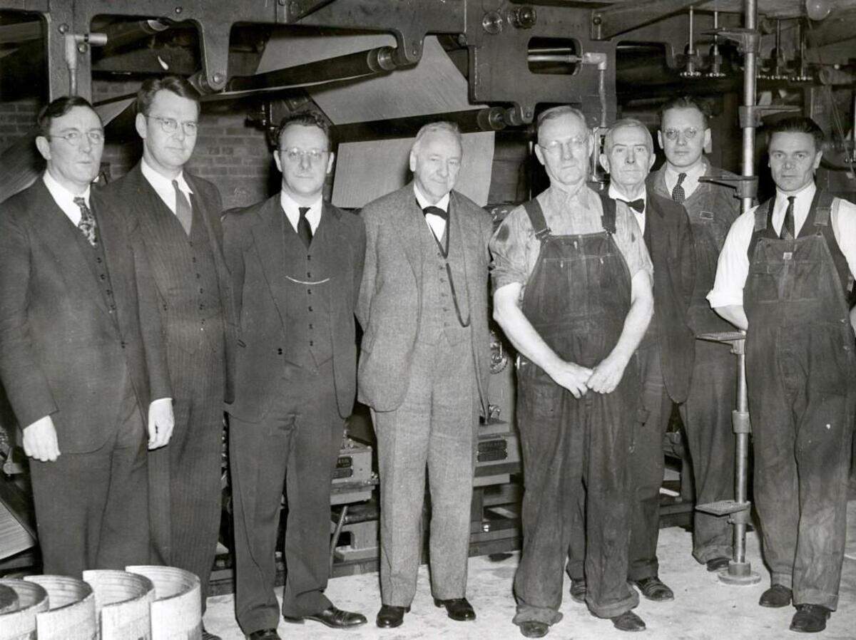 (L-R): Josephus Daniels Jr., Frank Daniels, Jonathan Daniels and Josephus Daniels Sr. stand beside press managers and workers at The News & Observer. No date.
