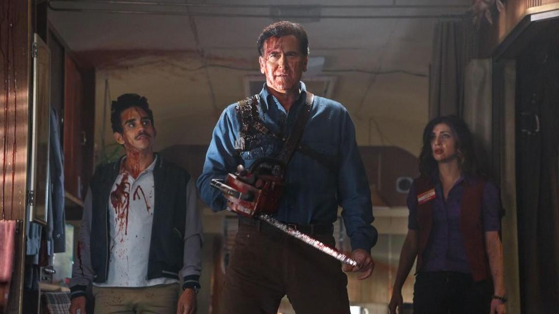 Bruce Campbell (center) is Ash, the world’s most unlikely hero, in the “Evil Dead” movies and now in the Starz sitcom “Ash Vs. Evil Dead.”