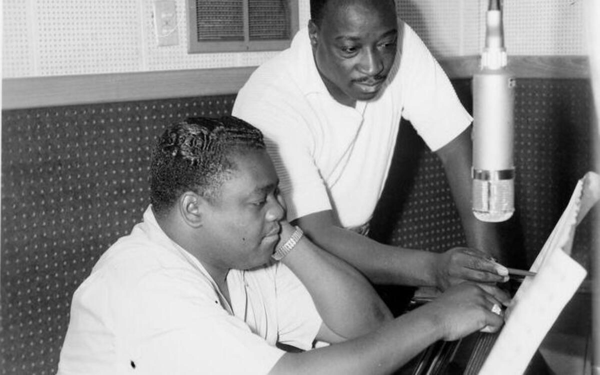 Fats Domino (seated) and Dave Bartholomew, producer/songwriter/bandleader and longtime collaborator, who co-wrote and produced most of Fats’ hits, at piano.