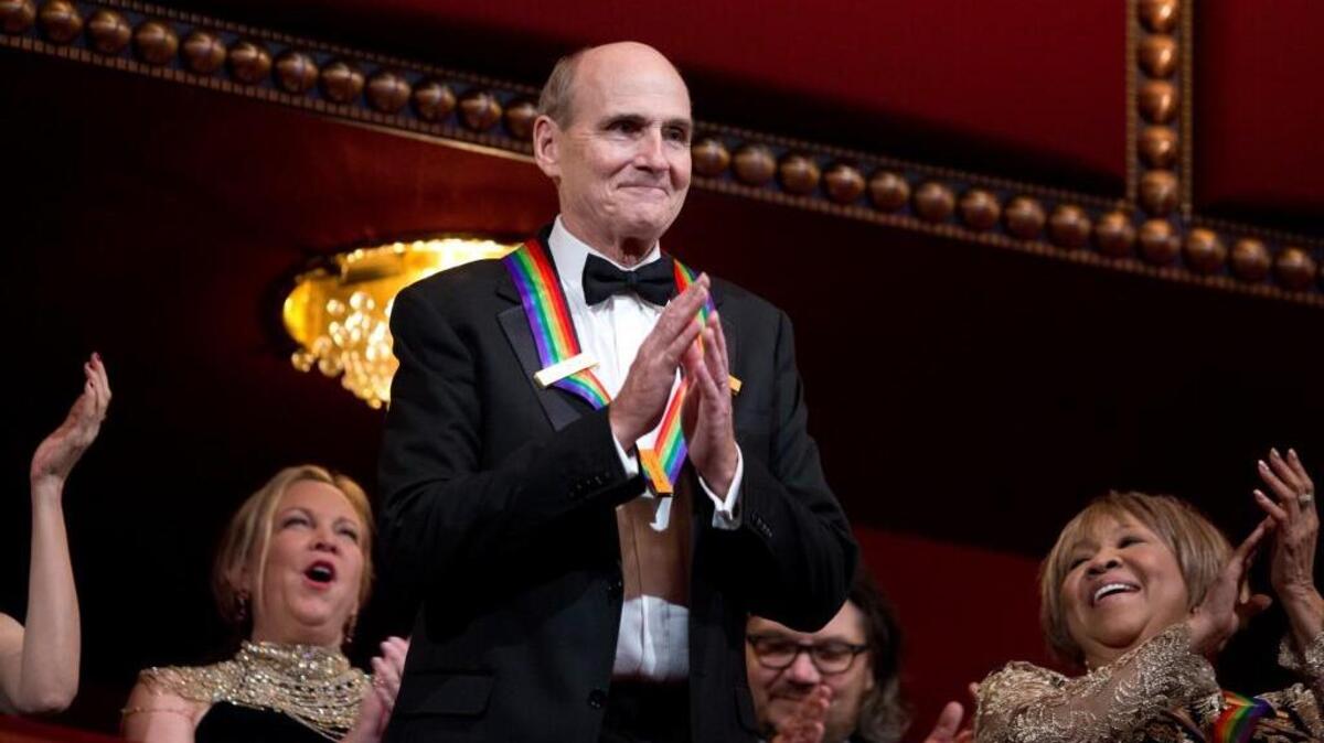 Recipient of the 2016 Kennedy Center Honor award, musician James Taylor, acknowledges the applause during the Kennedy Center Honors gala at the Kennedy Center in Washington, Sunday, Dec. 4, 2016. On the right is honoree gospel and blues singer Mavis Staples.