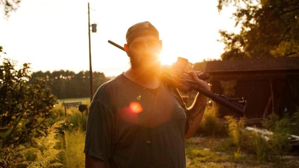 Alex Sutton stands on his farm after shooting a rifle in the field behind his house. Oct. 2, 2014, in Jackson Springs, North Carolina.