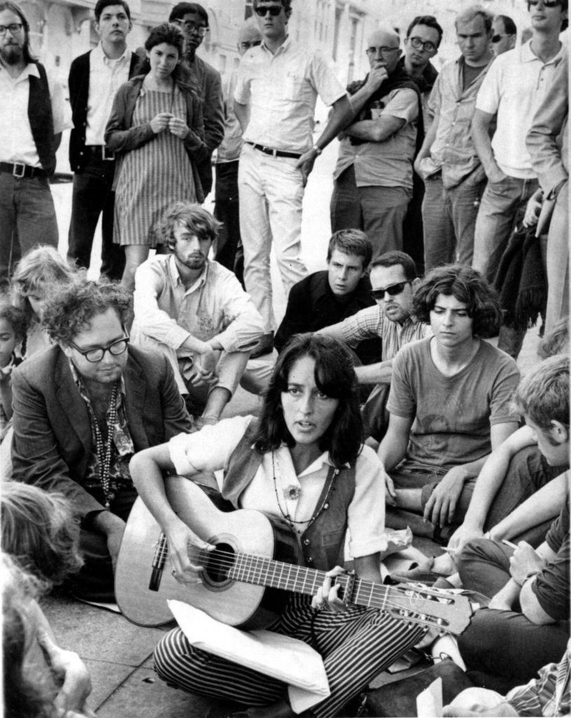 Folk singer Joan Baez sits at the corner of Haight and Ashbury and serenades hippies and tourists in a spontaneous concert in San Francisco, Calif., on Sept. 22, 1967. Baez is retiring from touring this year, but not before one last go-round, which includes a Triangle date.
