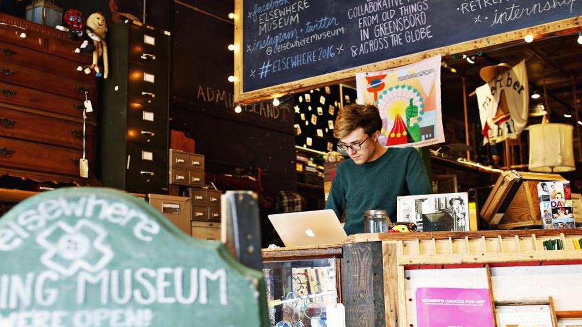 Luke Hodges, the media and documentation intern at Elsewhere in Greensboro, runs the front desk at the museum oduring hours when the public can visit. Elsewhere is a living museum, junk-culture archive and ongoing collaborative art project in downtown Greensboro.