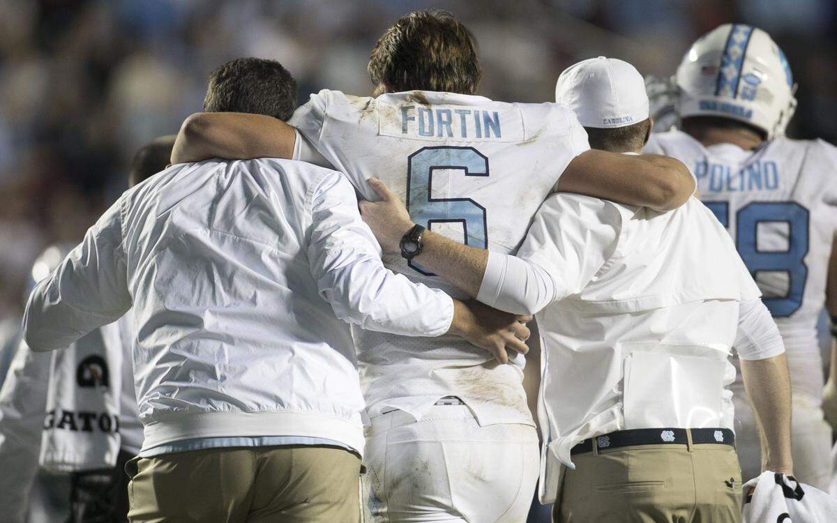 North Carolina quarterback Cade Fortin (6) is attended to following a hit in the second quarter against Virginia Tech on Saturday, October 13, 2018 at Kenan Stadium in Chapel Hill, N.C.