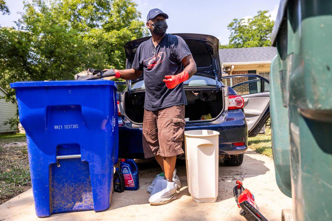 Dean Jernigan sorts through and discards items from his flood-damaged car in Durham’s Old Farm neighborhood near the Eno River on July 9, 2025. North Carolina Emergency Management recommends cleaning and cleansing anything that got wet after a flood.