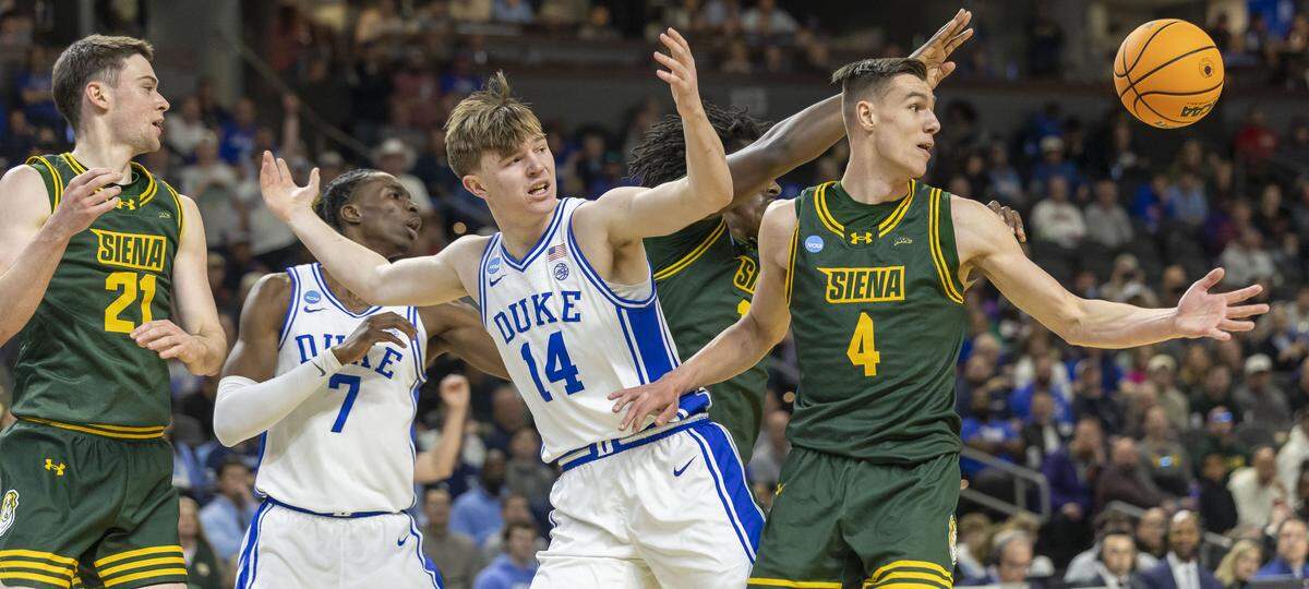 Duke guard Nikolas Khamenia (14) loses control of the ball under defensive pressure from Siena in the first half on Thursda in Greenville, S.C. Duke overcame an 11-point halftime deficit to win, 71-65.