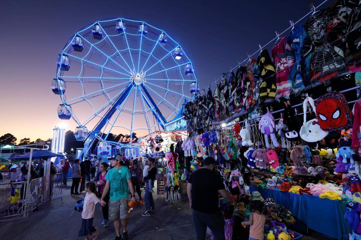 Fairgoers walk the midway at the N.C. State Fair in Raleigh, N.C., Thursday evening, Oct. 24, 2024.