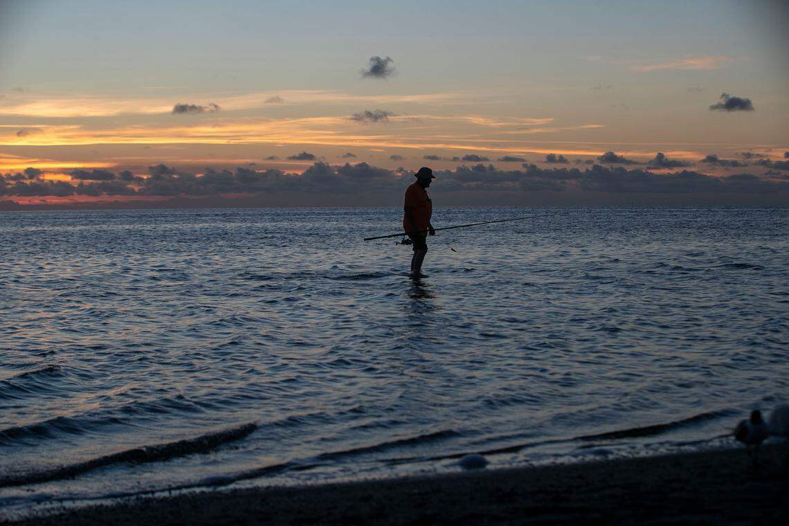 Del Purkey of Alexandria Va, walks to shore after fishing in the Pamlico Sound at Kite Point on Tuesday, June 29, 2021 near Buxton, N.C.